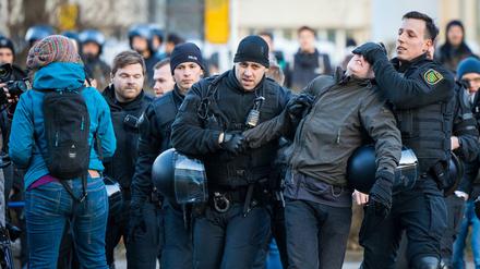 Polizisten führen in der Innenstadt während des Protests gegen einen Aufzug von Neonazis einen Gegendemonstranten ab.