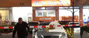 Polizist vor Absperrband und Autos am Tatort in Hanau.