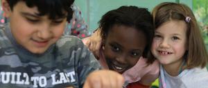 Kinder machen den Versuch "Tanzende Murmel" zum Thema Träge Körper und Fliehkräfte beim Projekt „Zauberhafte Physik“ der Bürgerstiftung Berlin.