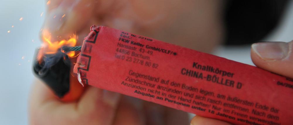Kurze Zündschnur: Ein Mann zündet einen Böller an.