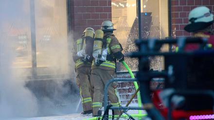 Einsatzkräfte der Feuerwehr löschen den Brand im Keller von einem Wohnhaus in der Hermannstraße in Berlin-Neukölln. Bei dem Brand sind am Samstagnachmittag mehrere Menschen verletzt worden. 