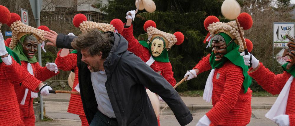 Da kommt selbst Kommissar Berg (Hans-Jochen Wagner) in Bedrängnis: Die Narren dreschen mit Schweineblasen auf die Besucher der Fasnet ein.