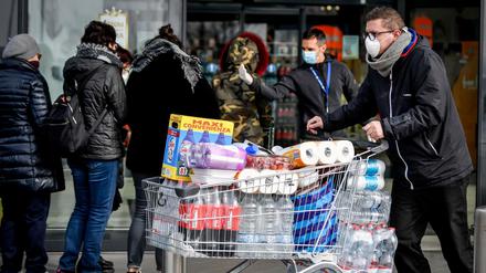 Menschen im italienischen Casalpusterlengo horten Lebensmittel. Vor dem Supermarkt müssen sie Schlange stehen.