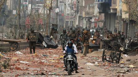 Sicherheitskräfte patrouillieren auf einer Straße in Neu-Delhi, auf der sich zuvor Befürworter und Gegner des Einwanderungsgesetzes bekämpft haben.