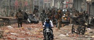 Sicherheitskräfte patrouillieren auf einer Straße in Neu-Delhi, auf der sich zuvor Befürworter und Gegner des Einwanderungsgesetzes bekämpft haben.