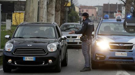 23.02.2020, Italien, Casalpusterlengo: Die Polizei hält Fahrzeuge an, die versuchen abgesperrte Zonen zu befahren oder zu verlassen. Mit drastischen Maßnahmen wie Sperrzonen will Italien die rasante Ausbreitung des Coronavirus Sars-CoV-2 stoppen. Mehrere Gemeinden in Norditalien wurden abgeriegelt, damit das Virus nicht in andere Regionen übergreift.