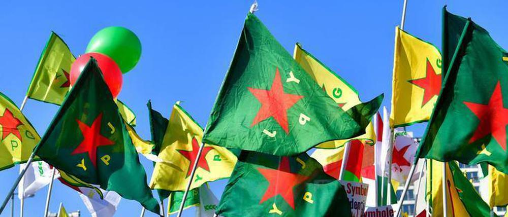 In Frankreich werden Kämpfer der YPG/YPJ in Paris empfangen, in Deutschland können ihre Symbole verboten werden. Demo in Berlin.