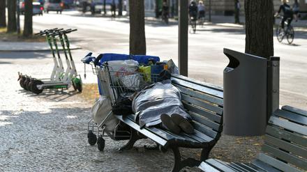 Ein Obdachloser schläft auf einer Bank auf dem Boulevard Unter den Linden. 