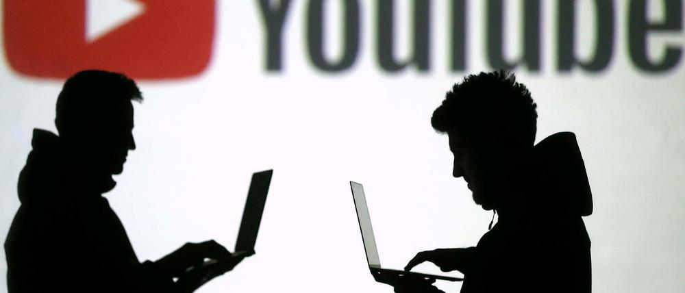 Silhouetten von Menschen mit Laptops.
