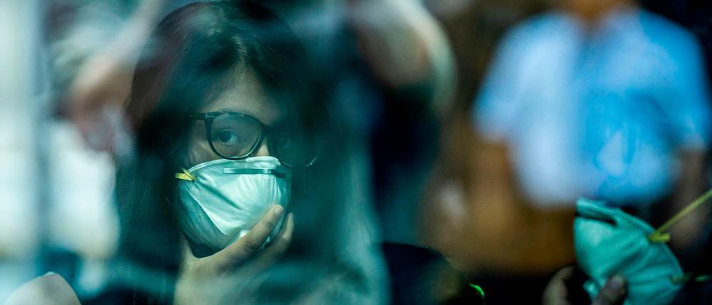 TOPSHOT - Passengers walk while wearing protective masks, as a preventive measure regarding the COVID-19 virus, at Jorge Chavez International Airport, in Lima on February 27, 2020. - So far, Peru has no record of the COVID-19 virus cases. (Photo by Ernesto BENAVIDES / AFP)