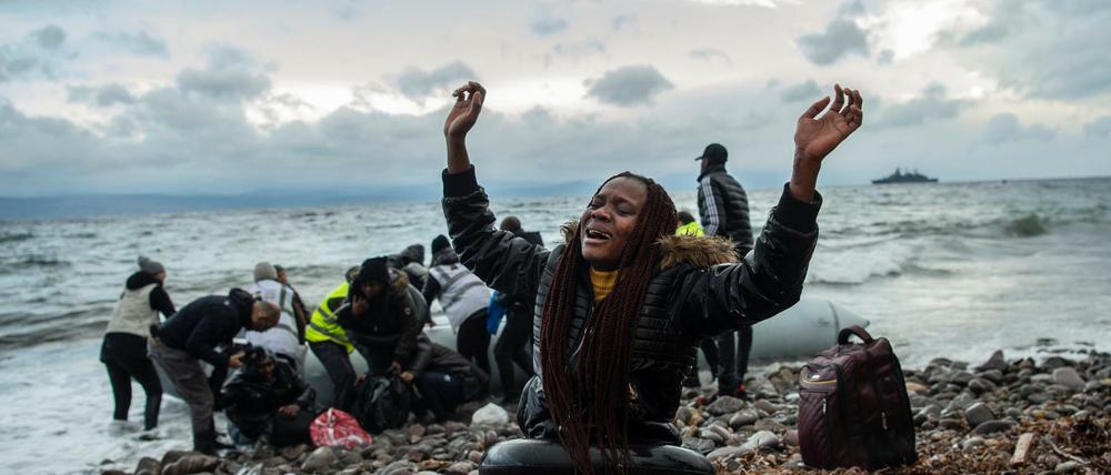 Eine Migrantin aus Afrika reagiert am Strand des Dorfes Skala Sikamias nach ihrer Ankunft aus der Türkei in einem Schlauchboot.