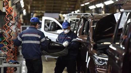 Mitarbeiter eines chinesischen Autobauers tragen Mundschutz.