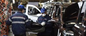 Mitarbeiter eines chinesischen Autobauers tragen Mundschutz.