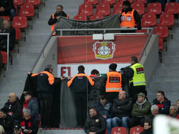 Wichtiger als Fußball: Ordner halten Decken, um den Notarzteinsatz während der Partie abzuschirmen.