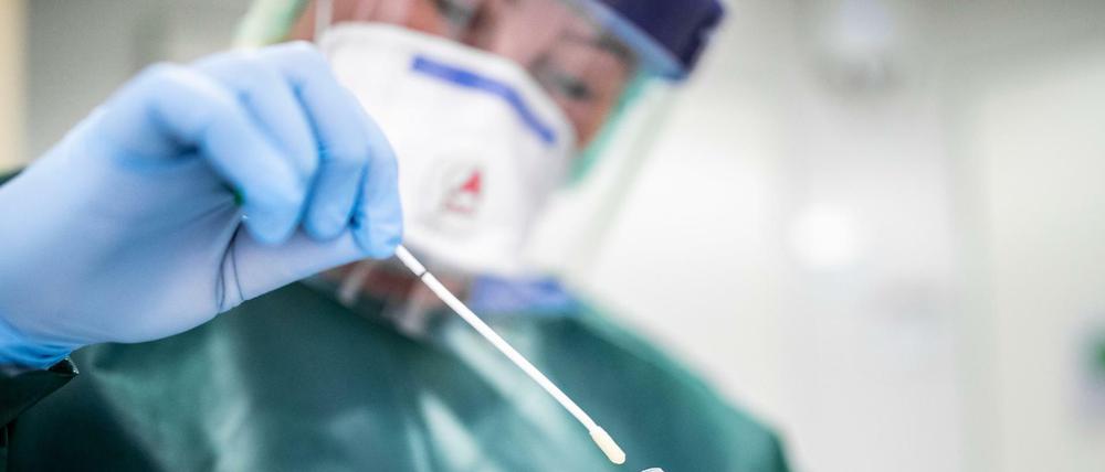 Eine Mitarbeiterin im Krankenhaus Essen hält ein Abstrichröhrchen in den Händen. 