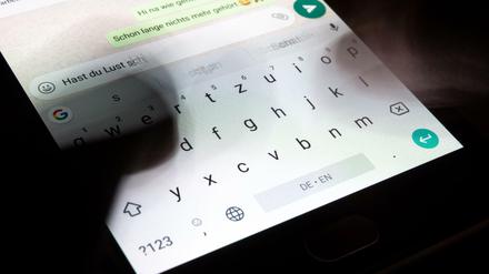 Eine Person gibt einen Text in die virtuelle Tastatur eines Smartphone ein.