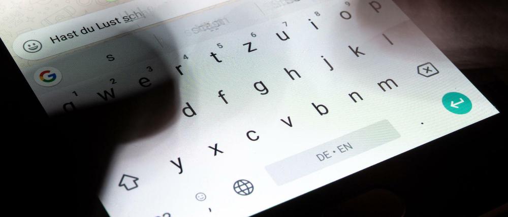 Eine Person gibt einen Text in die virtuelle Tastatur eines Smartphone ein.