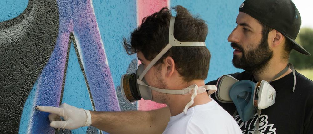 Der Graffiti-Lehrer Carlos Lorente (r.) gibt in Bayern Graffiti Workshops für junge Menschen.
