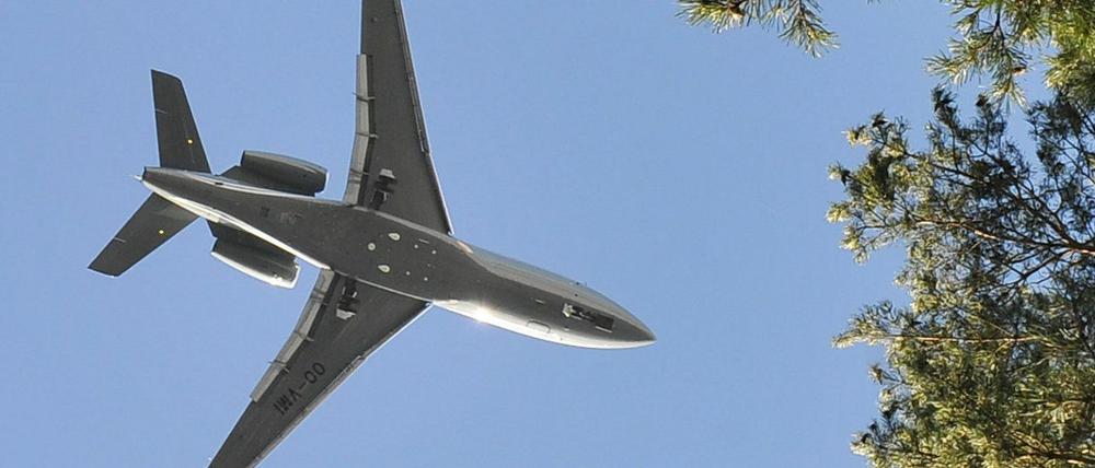 Flugzeug im Landeanflug über Baum.