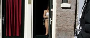 Eine Prostituierte an der Tür ihre Appartements im Rotlichtviertel von Amsterdam.