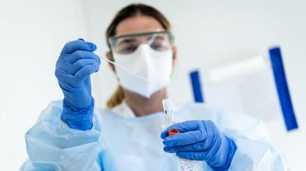 Nicht ohne Schutz: eine Krankenschwester beim Coronatest. Foto: Jean-Christophe Bott/KEYSTONE/dpa +++ dpa-Bildfunk +++ |