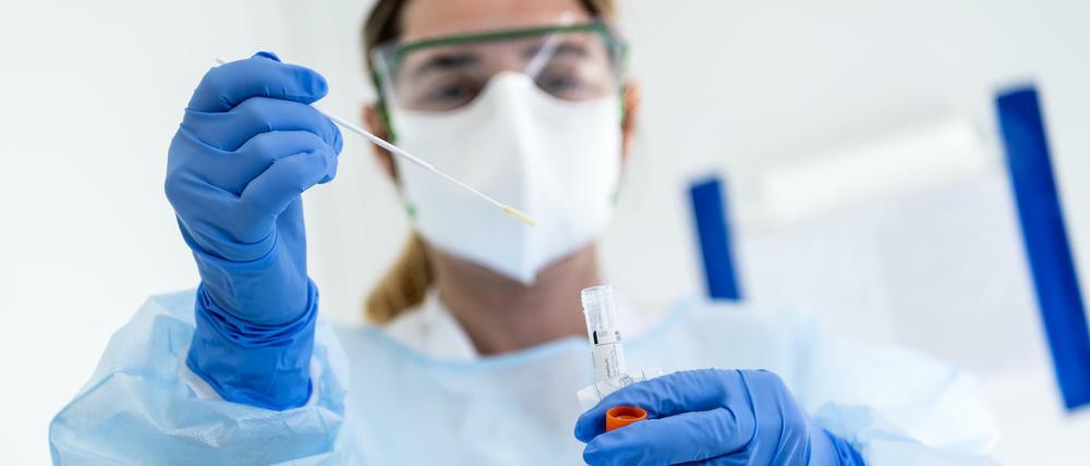 Nicht ohne Schutz: eine Krankenschwester beim Coronatest. Foto: Jean-Christophe Bott/KEYSTONE/dpa +++ dpa-Bildfunk +++ |