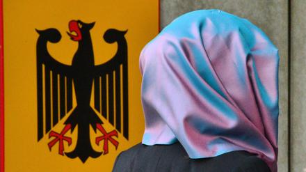 Kopftuch und Bundesadler an einer Behörde: Schwieriges Verhältnis.