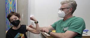 Facharzt Schulz-Gibbens impft den Zwölfjährigen Keyo Casper in der Aula der Max-von-Laue-Oberschule in Berlin-Lichterfelde.