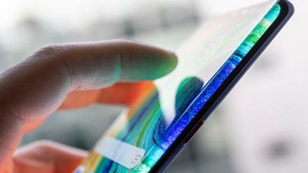 Eine Person hält ein Smartphone in der Hand (Symbolbild).