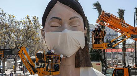Nach der Absage des Frühlingsfests in Valencia bekommt eine Figur einen Mundschutz.
