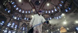 Ein Arbeiter in Schutzkleidung und mit Mundschutz desinfiziert die historische Fatih-Moschee in Istanbul als Vorsichtsmaßnahme gegen das Coronavirus.