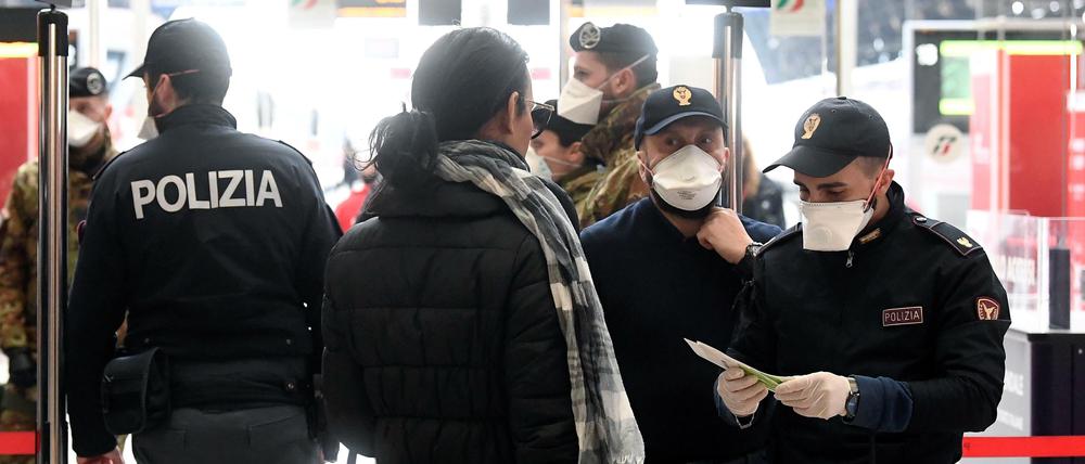 Polizei kontrolliert vor den Gleisen am Mailänder Hauptbahnhof die Reisegründe der Fahrgäste.