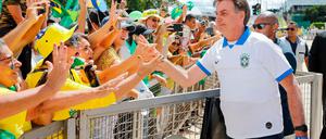 Brazilian President Jair Bolsonaro greets supporters in front of the Planalto Palace, after a protest against the National Congress and the Supreme Court, in Brasilia, on March 15, 2020. (Photo by Sergio LIMA / AFP)