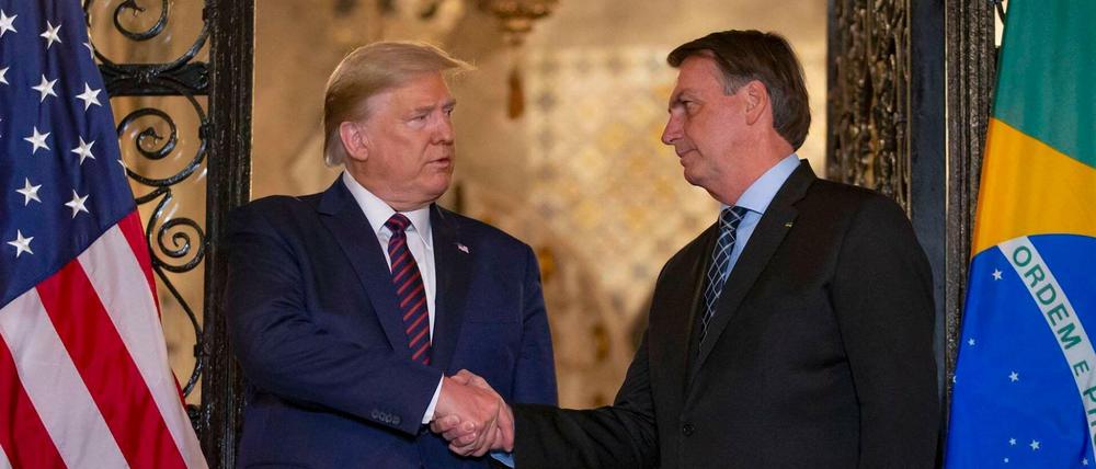 Donald Trump schüttelt gern Hände - hier mit Jair Bolsonaro, der sich inzwischen auf das Virus testen lassen hat.