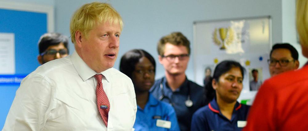 Premierminister Boris Johnson spricht während seines Besuchs im Watford General Hospital mit medizinischem Personal.