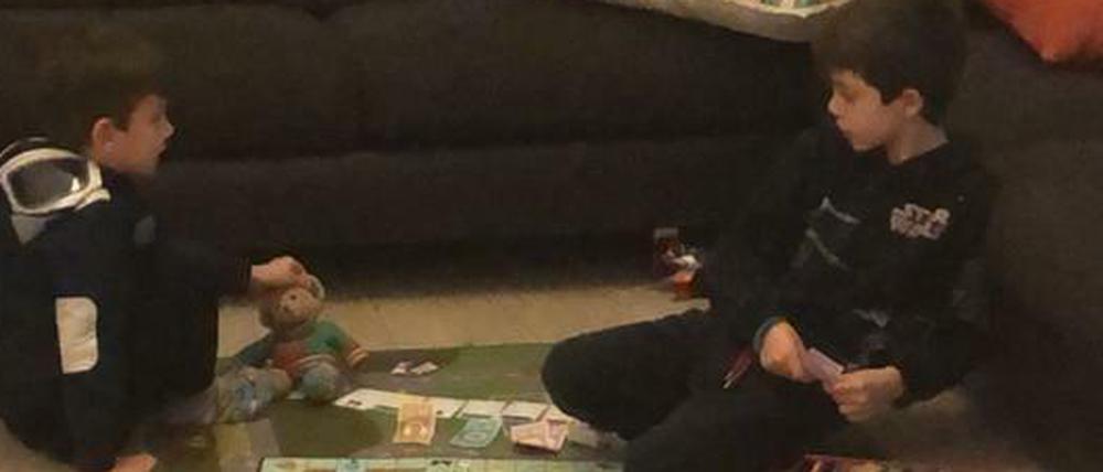 Immer zuhause. Rafael und Leonardo, fünf und sieben Jahre alt, spielen Monopoly