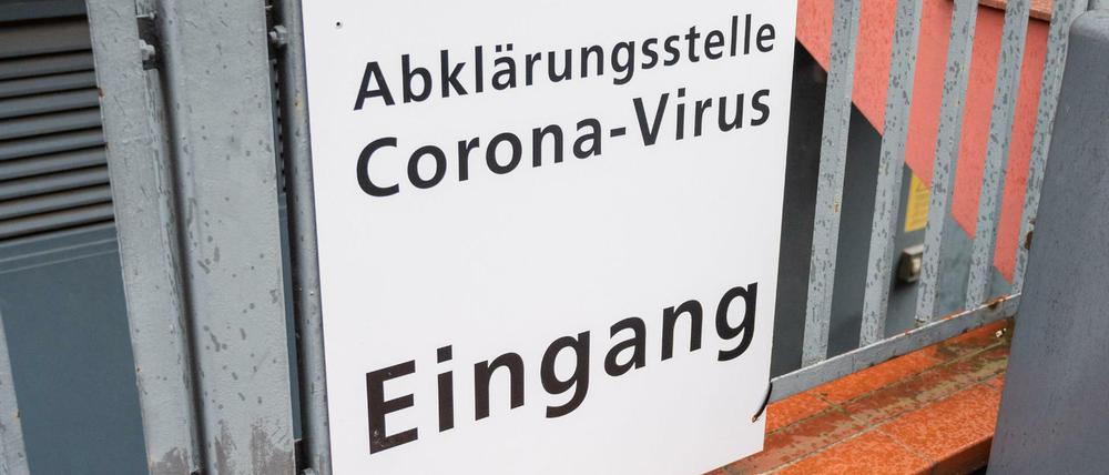 Schild an Zaun mit der Aufschrift: Abklärungsstelle Corona-Virus, Eingang.
