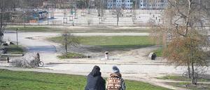 Ein junges Paar sitzt am Sonntag im leeren Mauerpark. Hier grillen, feiern, singen sonst Tausende.