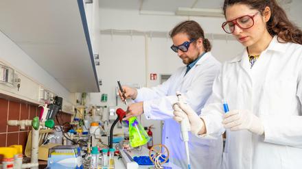 Eine Wissenschaftlerin und ein Wissenschaftler arbeiten in einem Chemielabor.