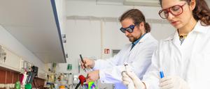 Eine Wissenschaftlerin und ein Wissenschaftler arbeiten in einem Chemielabor.