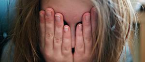Ein Kind schlägt seine Hände vor das Gesicht.