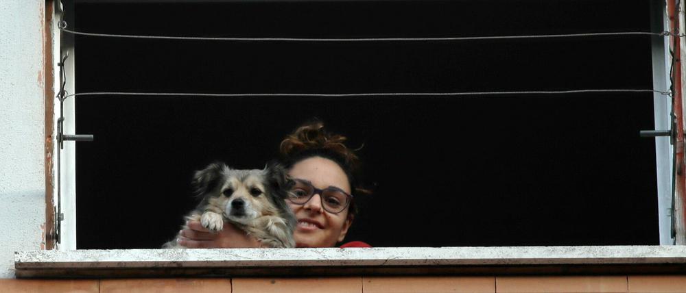 In Rom schaut eine junge Frau aus dem Fenster, während einer der vielen Flashmobs gegen Einsamkeit, die durch die Isolierung angesichts des Coronavirus-Ausbruchs verursacht wurden.