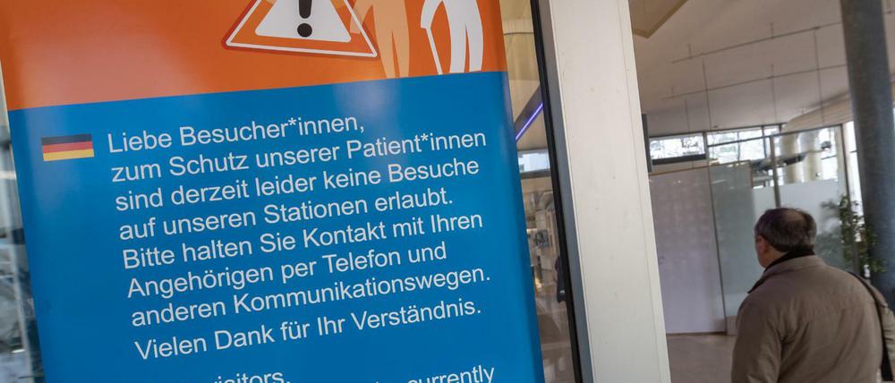 1Ein Hinweisschild, das über das Besuchsverbot auf den Stationen in einer Klinik in Bayern informiert.