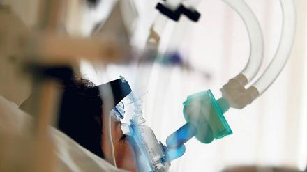 Eine Patienten wird in einem Krankenhaus mit einer Beatmungsmaschine versorgt.