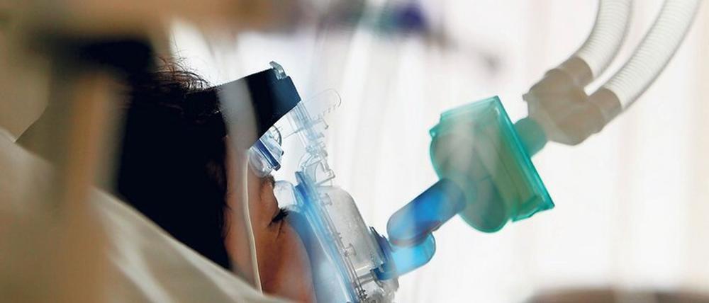 Eine Patienten wird in einem Krankenhaus mit einer Beatmungsmaschine versorgt.