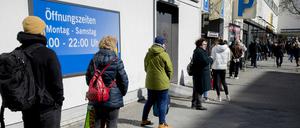 Menschen stehen in Berlin-Wilmersdorf vor einem Supermarkt Schlange.