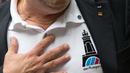 Ein AfD-"Flügel"-Mann zeigt ein Logo seiner Organisation - die soll nun aufgelöst werden
