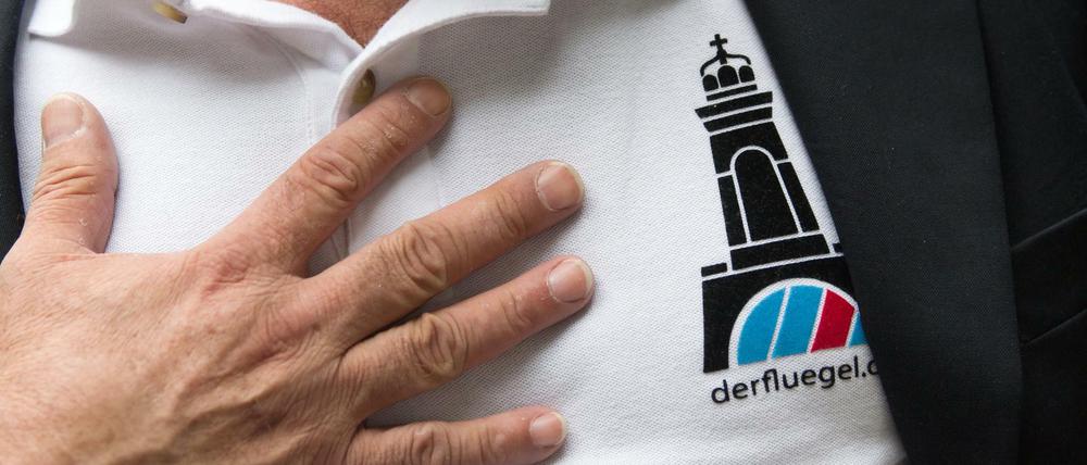 Ein AfD-"Flügel"-Mann zeigt ein Logo seiner Organisation - die soll nun aufgelöst werden