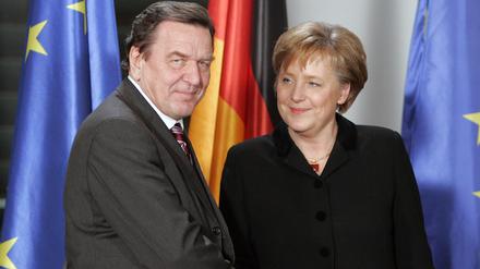 Der bisherige Bundeskanzler Gerhard Schröder übergibt das Bundeskanzleramt 2005 an die neue Kanzlerin Angela Merkel. 