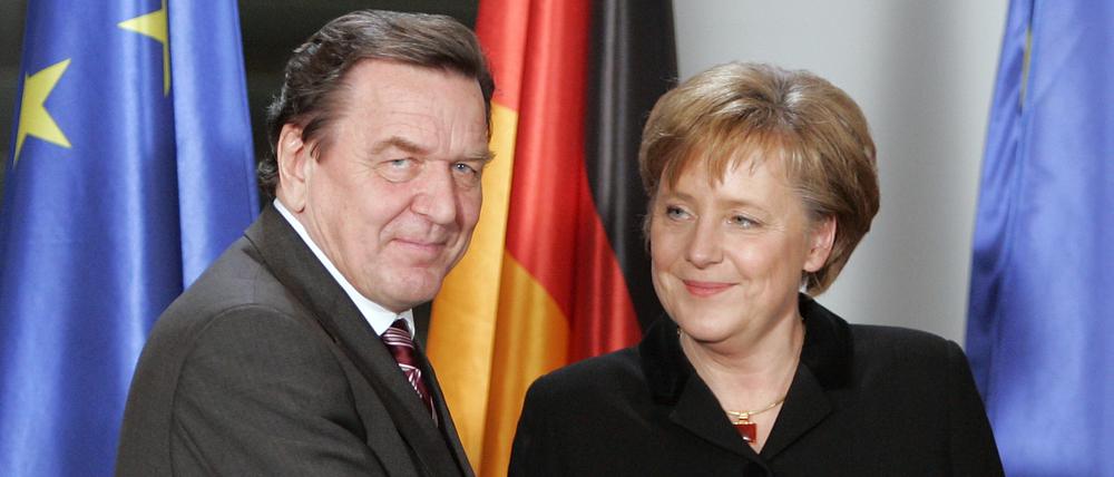 Der bisherige Bundeskanzler Gerhard Schröder übergibt das Bundeskanzleramt 2005 an die neue Kanzlerin Angela Merkel.